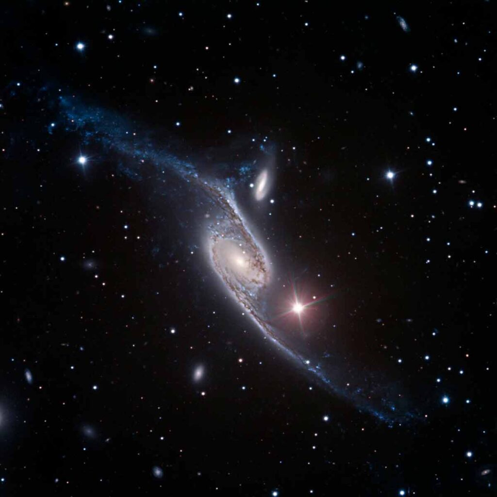 Детальное астрономическое изображение взаимодействующей пары галактик NGC 6782, демонстрирующее четкую спиральную структуру, центральный бар и кольцо, на фоне звездного неба с яркой звездой поблизости.